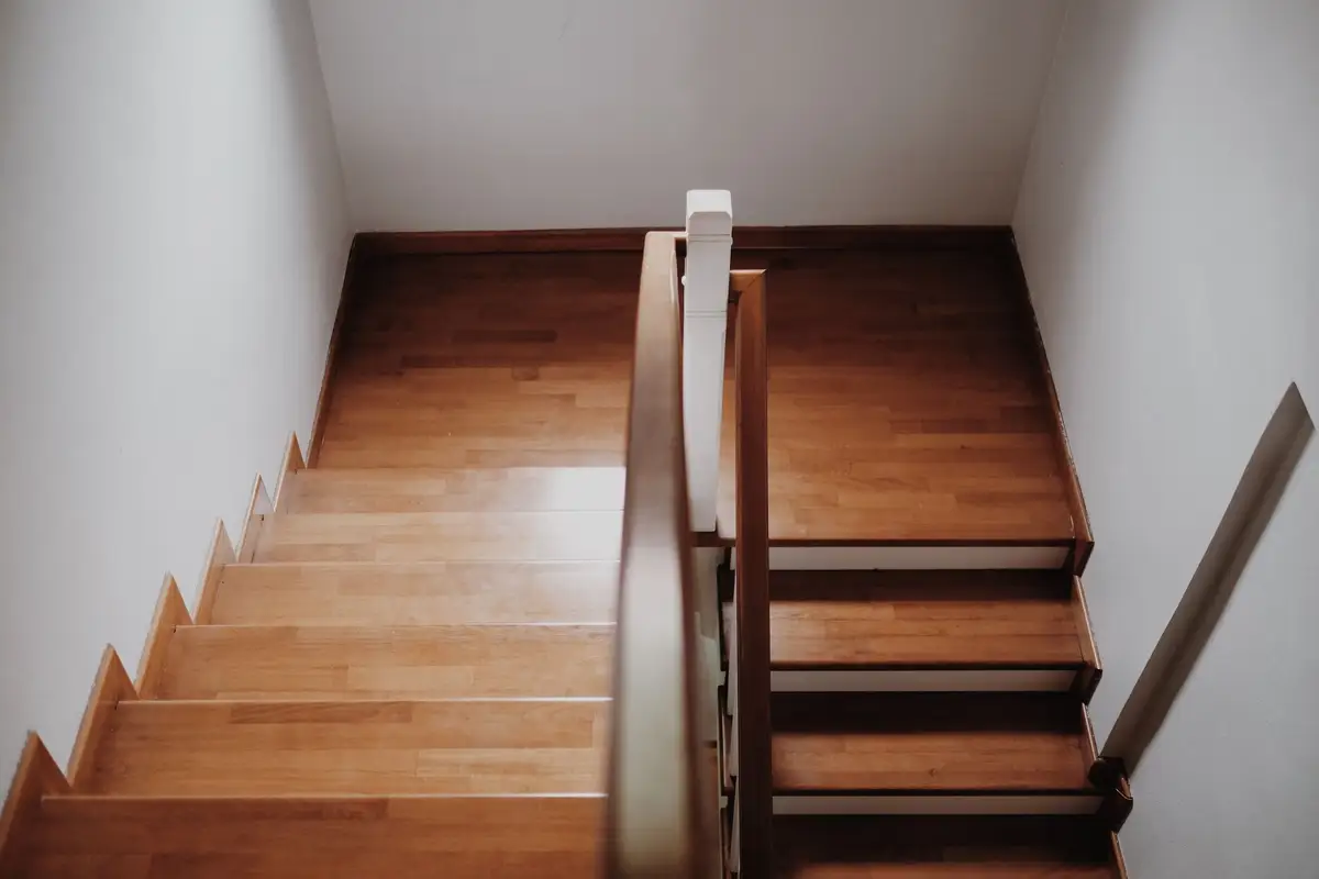 Dřevěné schody s tmavým zábradlím